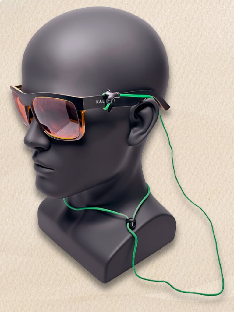 Black sunglasses with orange-tinted lenses and a green SpecTether, displayed on a matte black mannequin head.