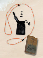 An orange SpecTether with a black mesh drawstring pouch, an attached black carabiner, and four black connector tips, displayed next to a brown cardboard SpecTether-branded box.